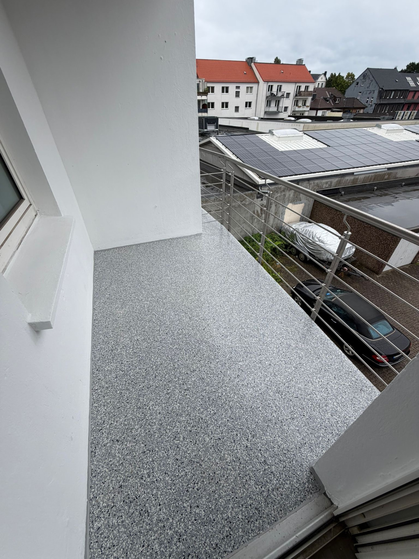 Balkon mit grauem Steinteppich nach der Sanierung